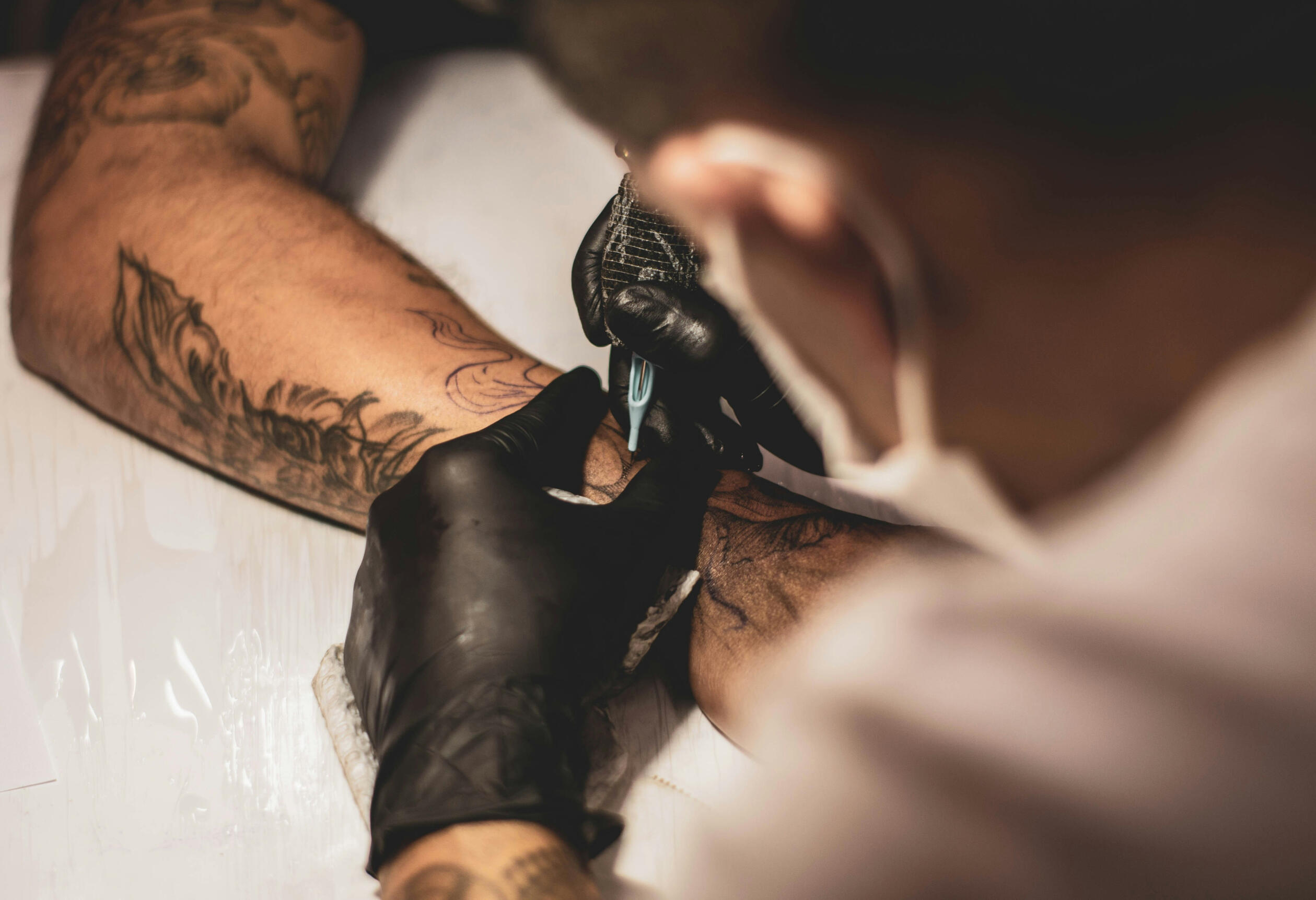 Men tattooing arm